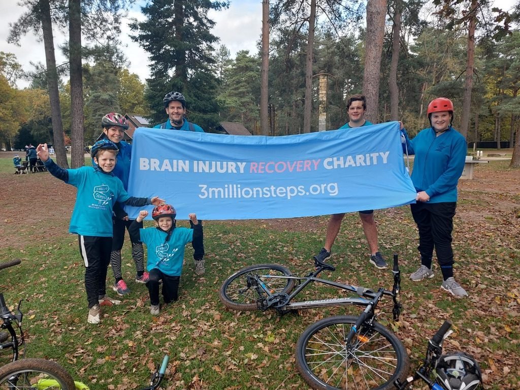 A family with bikes holding a 3 Million Steps banner