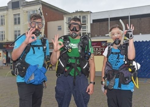 Three fundraisers in full scuba gear on the high street