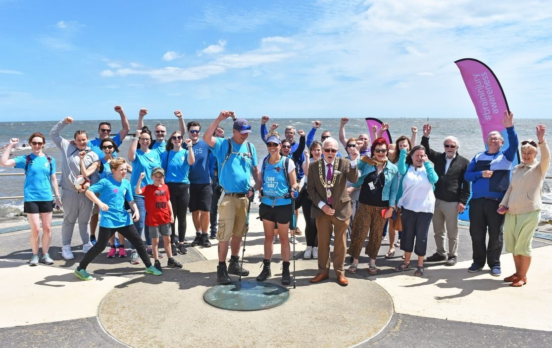 A big group of 3 Million Steps supporters celebrating by the sea
